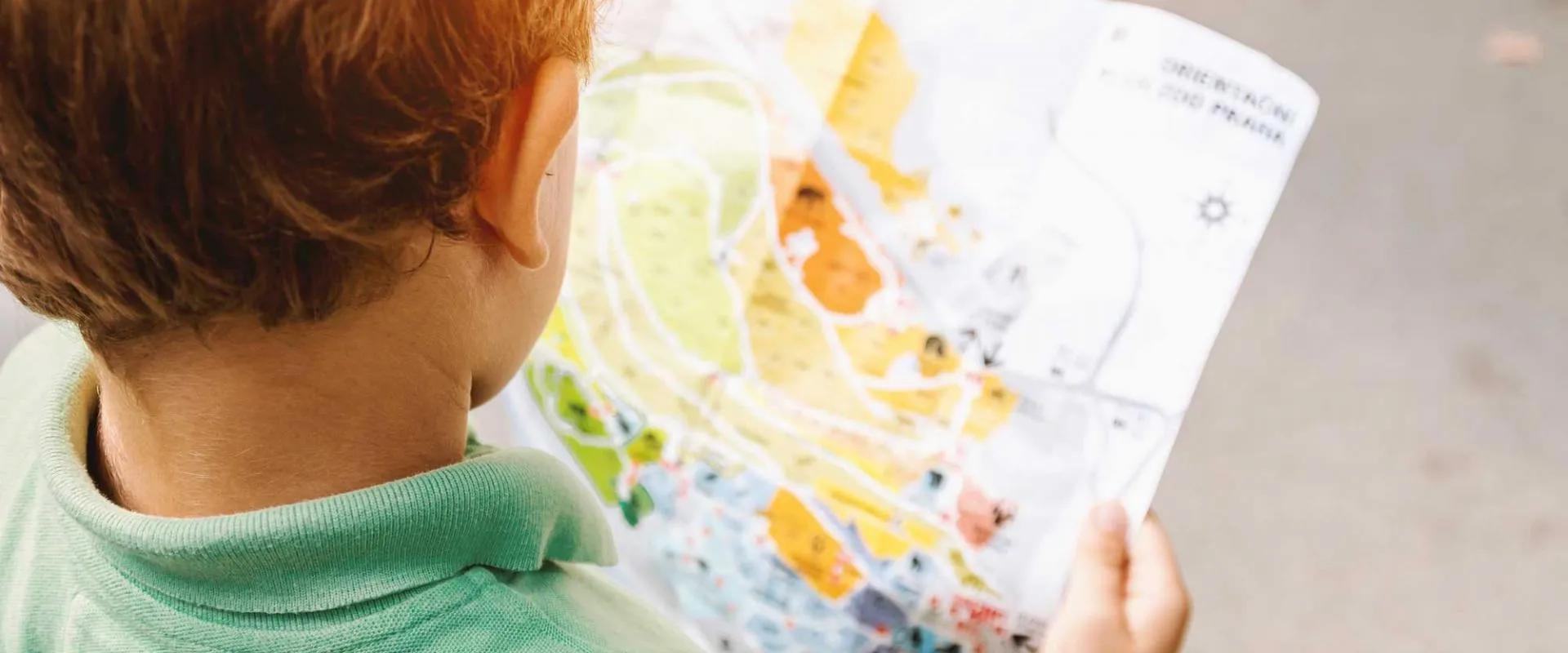A young boy intently examines a map, exploring its details with curiosity.